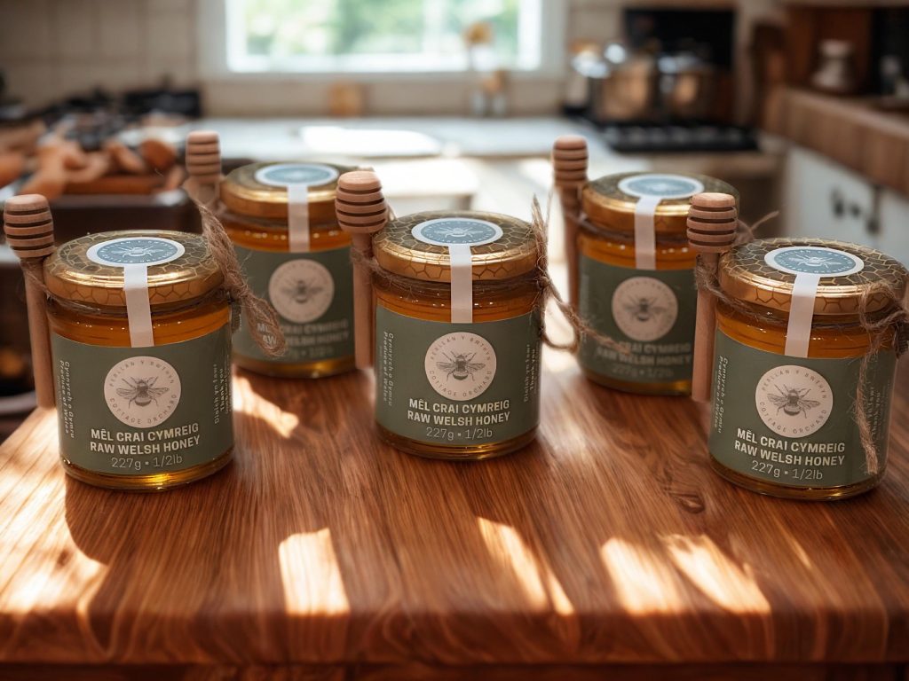 Five jars of raw Cottage Orchard Honey with their wooden dippers.
