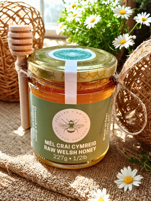 A jar of raw Cottage Orchard Honey with a wooden dipper.